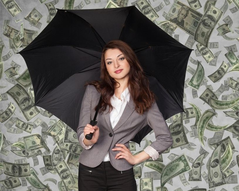 A woman holding an umbrella under a rainfall of currency notes