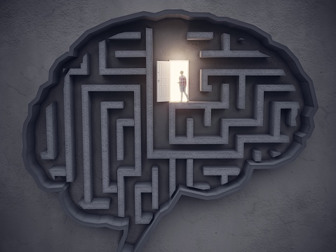 image of person finding light and the way out of a maze shaped brain