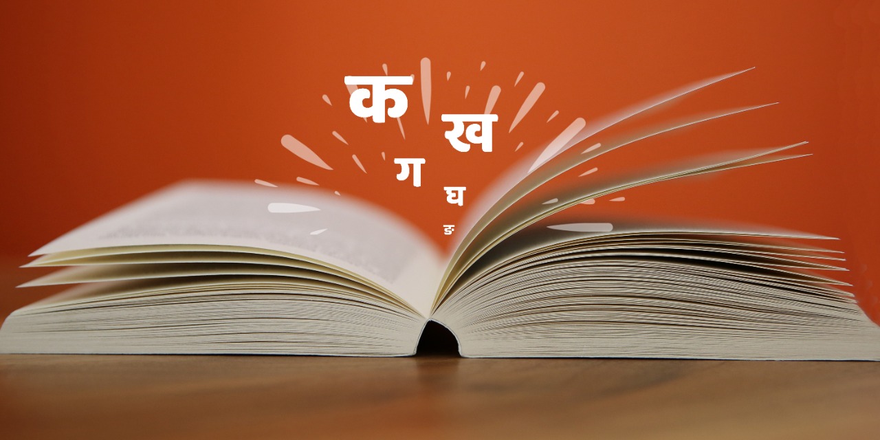 A thick textbook with Hindi alphabets flying out of it