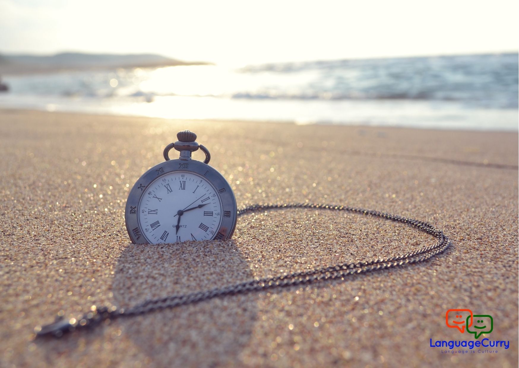 a pocket watch kept in sand on a beach