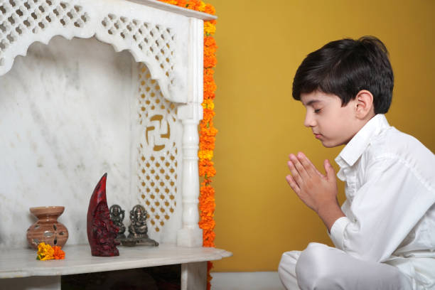 Small child praying to Ganesha