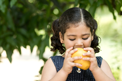 image of little girl eating mango